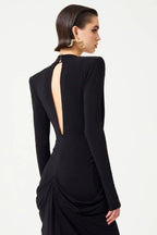 Back view of the black gown, highlighting the open back detail and draped skirt.