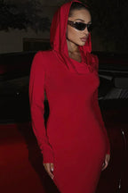 Close-up of a woman's face wearing a red hooded dress and sunglasses.