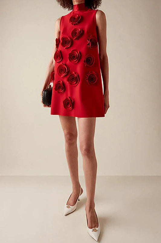 Red sleeveless A-line mini dress with appliqué roses on the front, worn by a model with a black clutch and white heels.