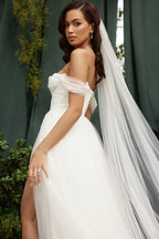Close-up of a model wearing a white off-the-shoulder wedding dress with a veil, showcasing the neckline and sleeves.
