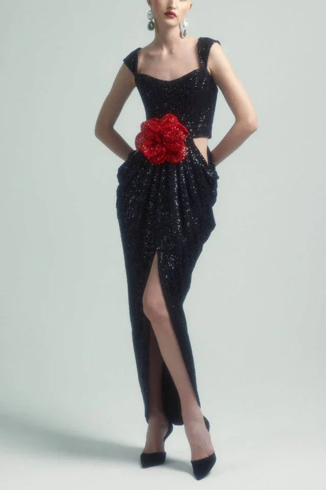 Woman wearing a black sequined gown with a red floral applique and a thigh-high slit. Main image
