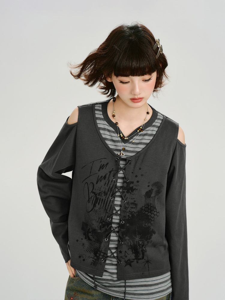 Model looking down, showcasing the layered grey top with graphic print and cold shoulder details.