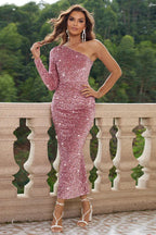 Woman wearing a pink sequined one-shoulder long-sleeve ruched dress.