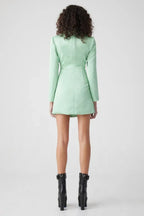 Back view of a model in a mint green blazer and skirt set.