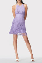 Full body shot of a woman in a purple fringe mini dress