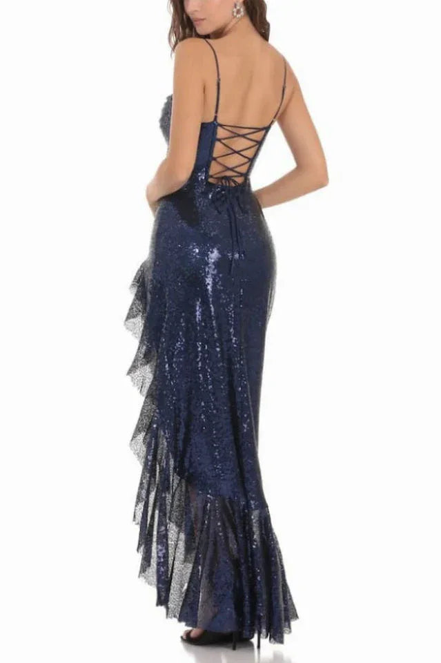 woman wearing a navy blue sequined gown with a high slit and ruffle trim, back view showing lace-up detail