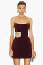 Woman wearing a burgundy velvet strapless mini dress with a heart-shaped cutout embellished with rhinestones on the side.