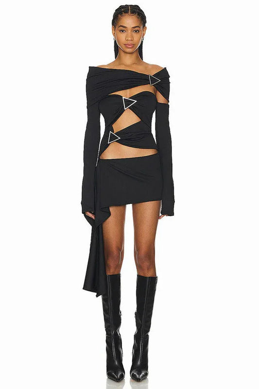 Model wearing a black asymmetrical knit dress with cut-out details and silver hardware.
