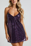 Woman wearing a purple sequin slip dress with spaghetti straps and a v-neckline.