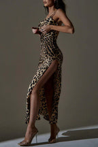 Woman in a leopard print satin maxi dress with a high slit, adjusting the top of the dress.