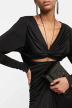 Close-up of the bodice of a black ruched dress with a plunging neckline and cut-out detail