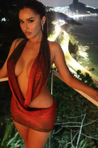 Woman in a red and black sheer mesh halter mini dress with floral print, looking to the side on a balcony