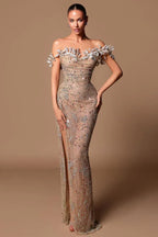 Woman in a sparkling nude off-the-shoulder gown with a thigh-high slit.
