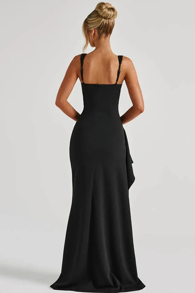 Rear view of a woman wearing a black floor-length dress with a high slit