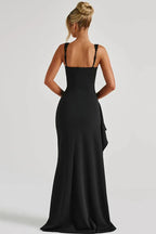 Rear view of a woman wearing a black floor-length dress with a high slit