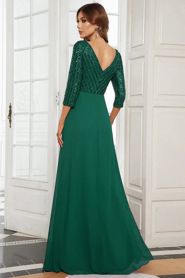 Back view of a woman in a floor-length emerald green sequined formal gown with 3/4 sleeves.
