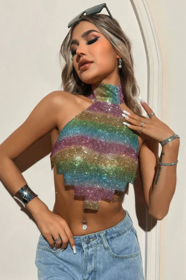Woman wearing a rainbow gradient halter crop top with sparkling embellishments. Main image