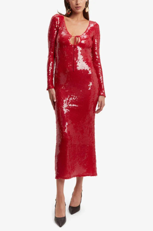 Woman wearing a long-sleeved, red sequined midi dress with a tie-front neckline, shown from the front.