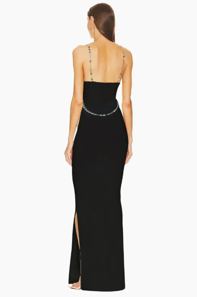 Back view of a black sleeveless maxi dress with chain straps and a chain belt.
