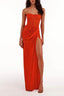 Full-length view of a woman in a strapless orange ruched gown with a high slit