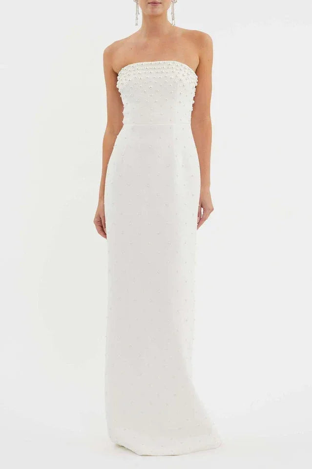 Woman wearing a white strapless pearl-embellished column gown from the front