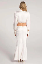 Back view of a woman wearing a white satin two-piece set.