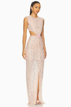 side view of a model in a blush pink sequined column gown with a high slit and cut-out waist
