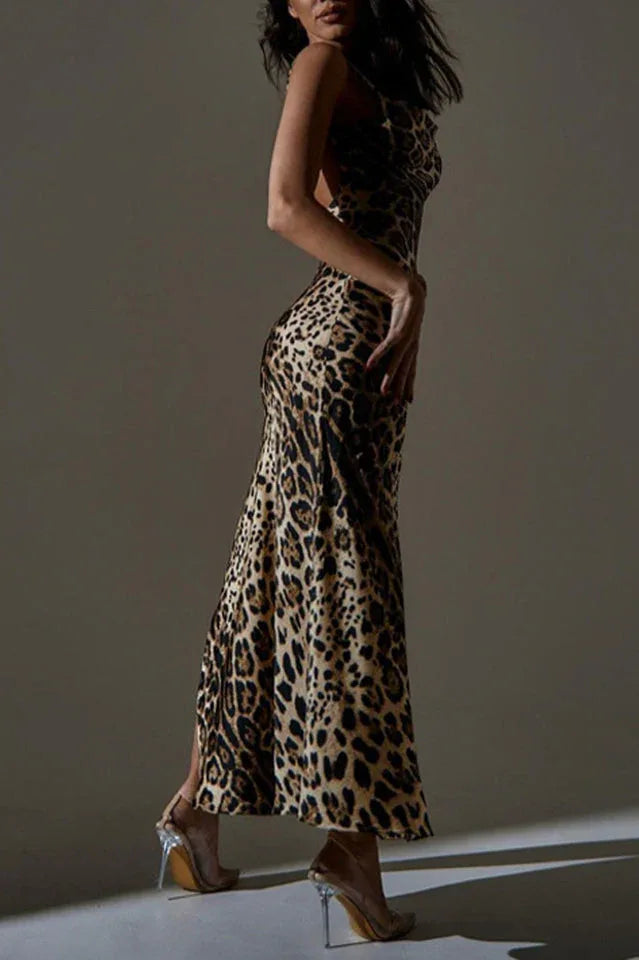 Side view of a woman in a leopard print satin maxi dress with a high slit, showcasing the back detail.