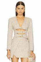 Front view of a beige blazer dress with cut-out details and buckle closures.