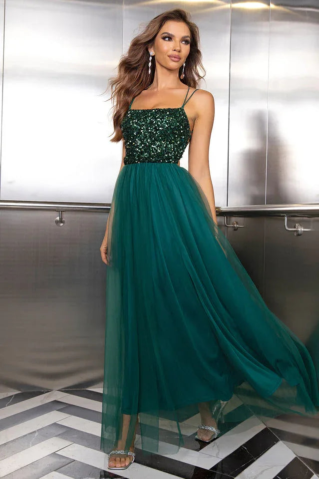 woman in a dark green sequined and tulle evening gown