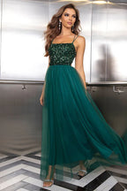 woman in a dark green sequined and tulle evening gown
