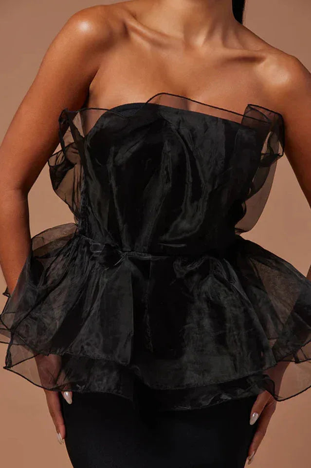 Close-up of the black ruffled peplum bodice of a formal gown.