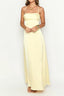 woman wearing a pale yellow satin maxi dress with spaghetti straps and a sweetheart neckline, hands clasped in front