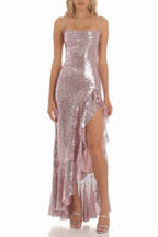 woman wearing a rose gold sequined gown with a high slit and ruffle trim, front view