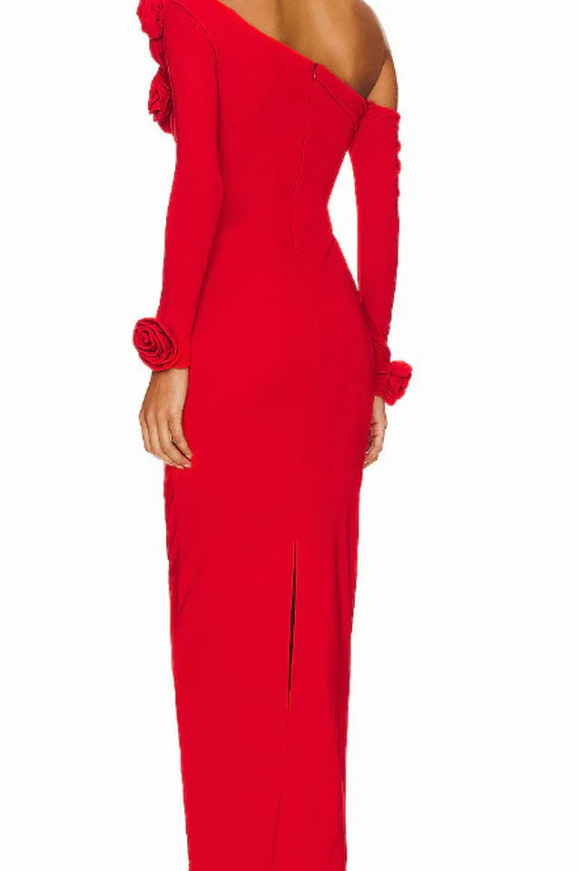 Back view of a red column gown with a center back slit and rose embellishments on the shoulder.