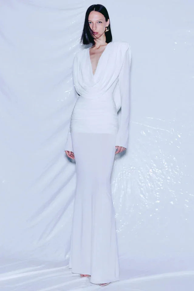 Model wearing a long white draped dress with ruched waist and mermaid hem. Main image