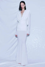 Model wearing a long white draped dress with ruched waist and mermaid hem.