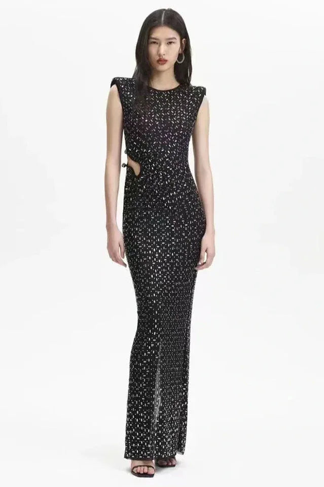 Woman in a black floor-length sequined mesh dress with cut-out waist and side slit Main image