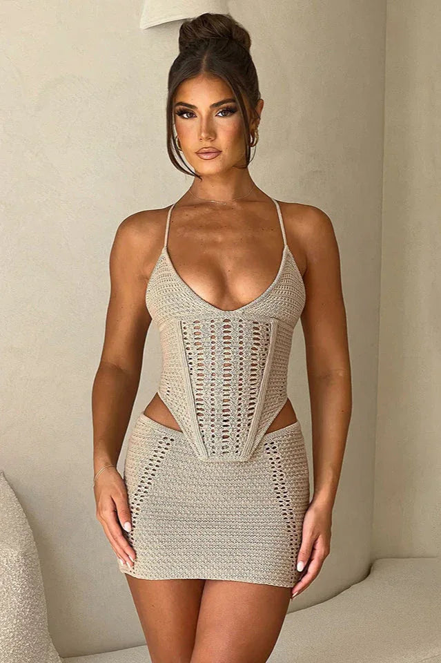 Woman wearing a beige crochet knit corset top and matching mini skirt, front view Main image