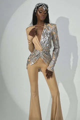 Close-up on the upper body of a woman in a designer jumpsuit, highlighting the sequined detailing and plunging neckline.
