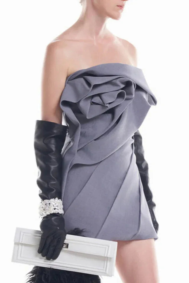 Front view of a model in a grey strapless dress with a rose bodice, black gloves, and a white clutch.