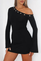 Woman wearing a black one-shoulder long-sleeve bodycon dress with flared sleeves and decorative grommets.