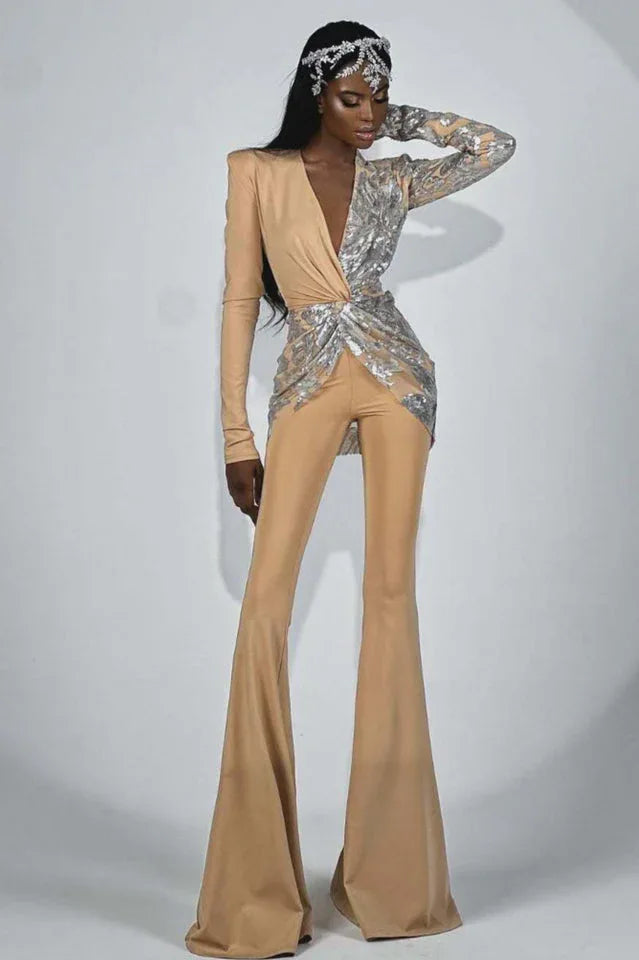Fashion model posing in a glamorous tan and silver sequined jumpsuit with a flowing silhouette and intricate embellishments.