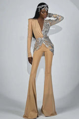 Fashion model posing in a glamorous tan and silver sequined jumpsuit with a flowing silhouette and intricate embellishments.