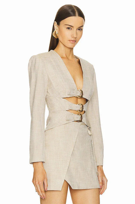 Side view of a beige blazer dress with cut-out details and buckle closures.