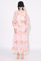 Woman wearing a pink floral print maxi dress from the front