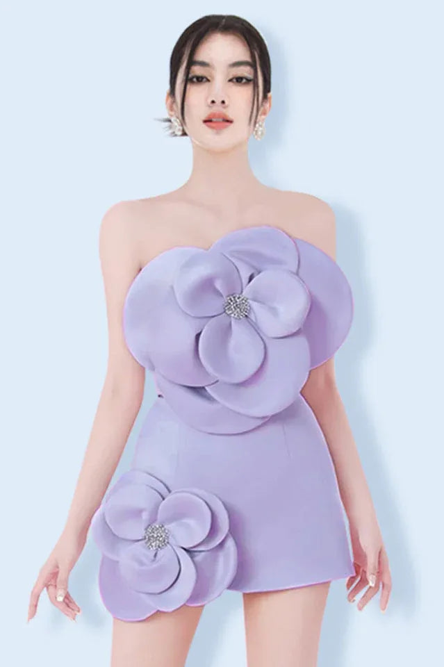 A model wearing a lavender strapless mini dress with large floral appliques on the bust and hip, adorned with sparkling embellishments at the center of each flower. Main image