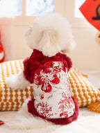 Back view of a white fluffy dog wearing a red and gold traditional Chinese-style coat with floral embroidery