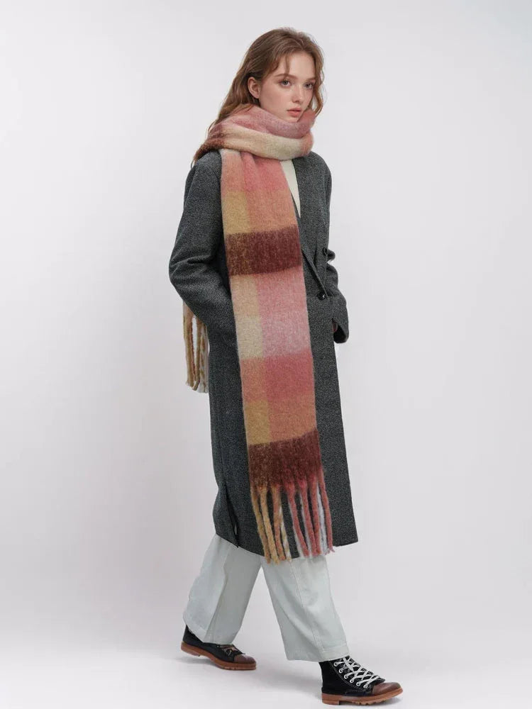 Model wearing a grey coat and pink plaid scarf