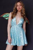 Woman wearing a light blue sequined mini dress with fairy wings